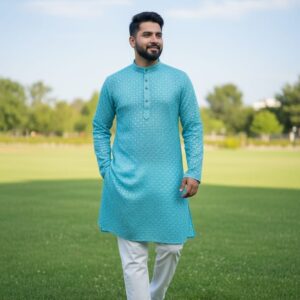 A man wearing a traditional embroidered kurta with straight trousers, walking outdoors on green grass.